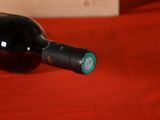 a bottle of wine sitting on a red table cloth
