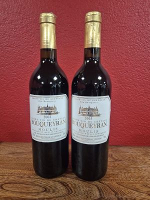 deux bouteilles de vin rouge posées sur une table en bois