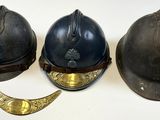 trois casques sont alignés les uns à côté des autres sur une surface blanche
