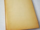 an old book sitting on top of a white table covered in paper