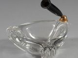 un cendrier en verre avec une poignée noire sur fond blanc