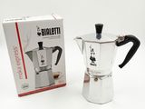 une petite cafetière posée à côté d'une boîte de café
