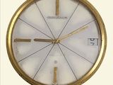 une horloge dorée avec un cadran blanc sur fond blanc