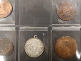 six different types of coins in a display case on a table