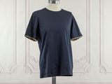navy blue t - shirt on mannequin stand in front of a white wall