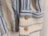 a close up of a white shirt with blue stripes and buttons