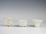 trois vases en verre blanc posés sur une surface blanche