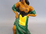 figurine représentant une femme vêtue d'une robe verte et jaune, les mains sur les hanches