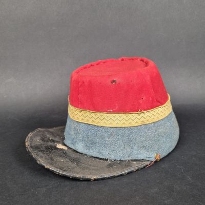 un bonnet rouge et bleu orné d'un ruban jaune