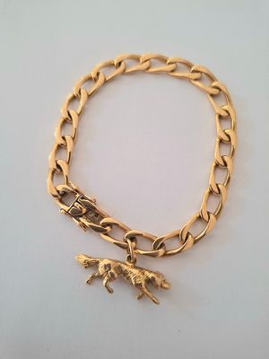 gold plated bracelet with a dog charm on it