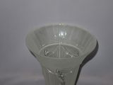 a white glass vase with a flower inside of it