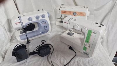 several sewing machines are lined up on a white sheet