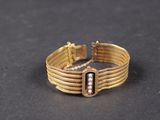 gros plan d'un bracelet en or sur une surface noire