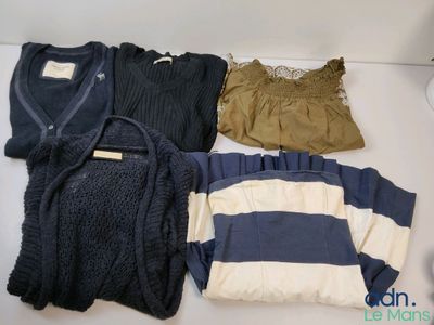 a pile of clothes on a table next to a lamp