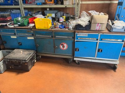 un établi bleu au milieu d'une pièce remplie d'outils
