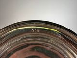 a close up of a silver plate with a bird on it