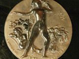 an image of a silver coin with a woman and a dog on it