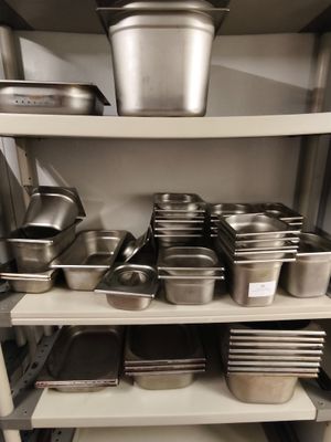 de nombreuses casseroles et poêles sur les étagères de la cuisine