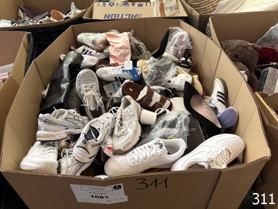 many pairs of shoes in a cardboard box on the floor