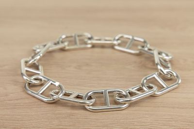 silver plated link bracelet with square links on a wooden surface