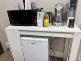 une petite table blanche sur laquelle est posé un micro-ondes