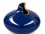 a blue vase with a gold rim on a white background