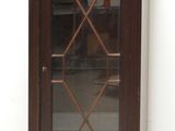 une petite armoire en bois munie d'une porte vitrée