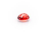 a close up of a red diamond on a white surface