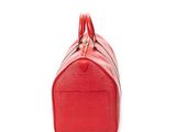 the red louis vuitton bag is sitting on a white surface