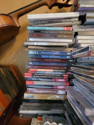 a stack of cds on a table next to a guitar