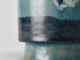 a close up of a blue vase with a black and white design