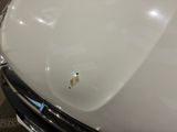 a close up of a white car with a rusted hood
