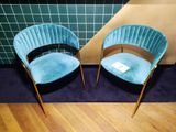 une paire de fauteuils en velours bleu aux pieds dorés