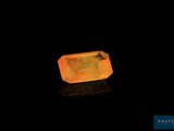 a yellow quartz stone on a black surface
