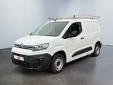 La camionnette blanche est garée dans une pièce au sol noir.