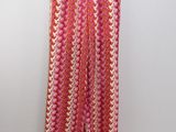a pink and orange patterned pants hanging on a hanger