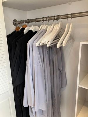 une photo d'un placard avec des vêtements suspendus à une tringle