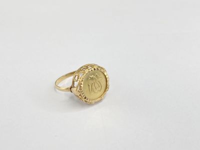 a close up of a gold ring on a white surface