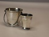 un seau en argent et une coupe en argent posés sur une table