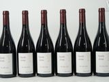 six bottles of wine are lined up in a row on a table