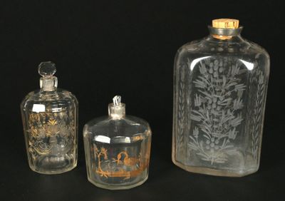 trois bouteilles en verre posées les unes à côté des autres sur une table