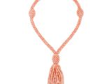 un collier de perles roses orné d'un pompon, sur fond blanc
