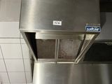 une cuisinière en acier inoxydable dans une cuisine au sol carrelé