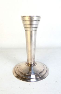 un bougeoir en argent posé sur une table blanche