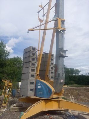 une grue posée au sommet d'un tas de parpaings