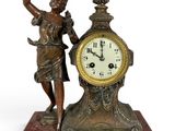 une statue représentant une femme tenant un oiseau à côté d'une horloge
