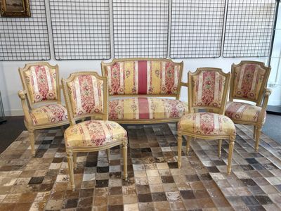 quatre chaises et un canapé posés sur un tapis dans une pièce