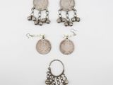 three pairs of silver earrings and a silver coin
