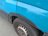 a close up of a blue truck with a flat tire