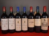 six bottles of wine are lined up on a red table